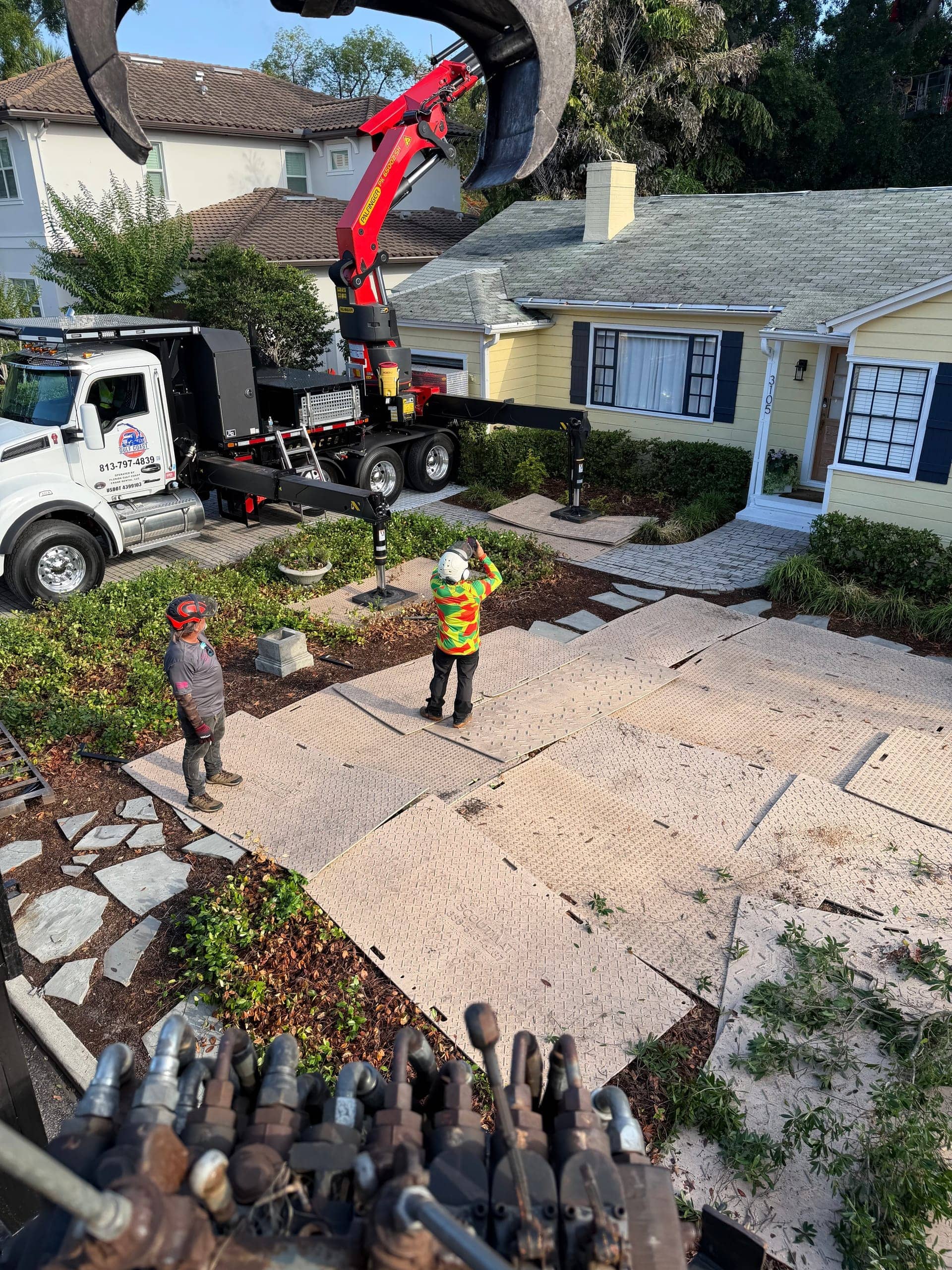 T.E.A.M. crew protecting a driveway with ground mats during a crane-assisted tree removal